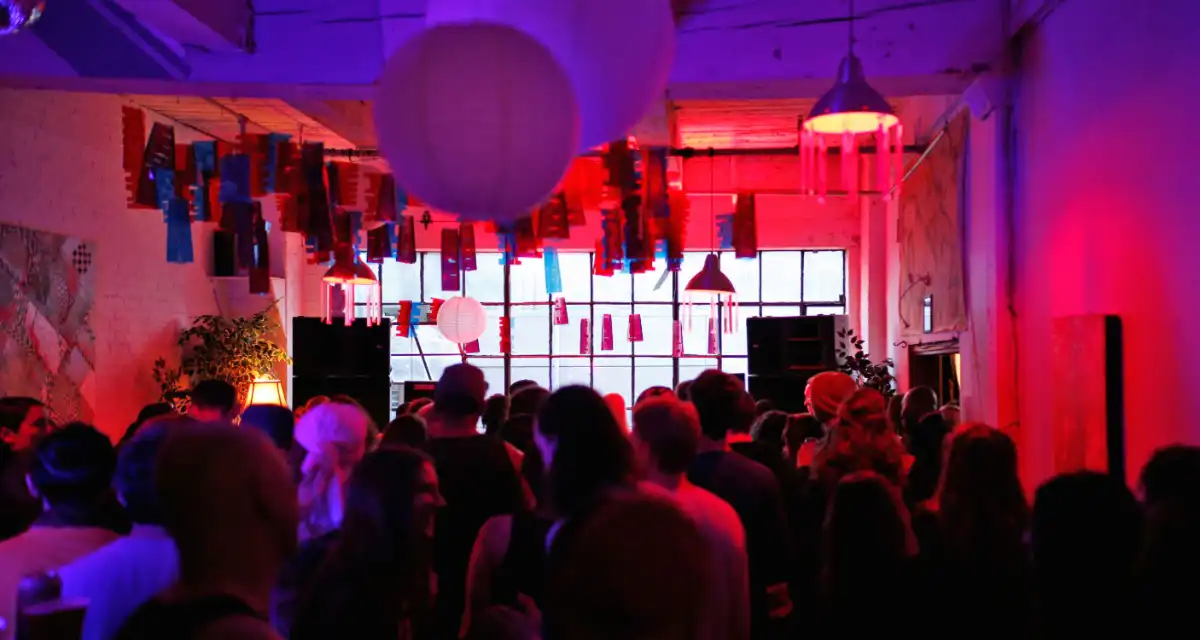 A crowded room lit red and purple