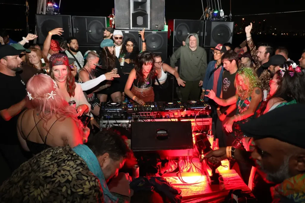 A DJ with dancers and bass around her