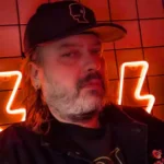 DJ Ali Black with cap and red neon lightning bolts behind