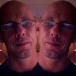 Mirror image of a red lit bald man