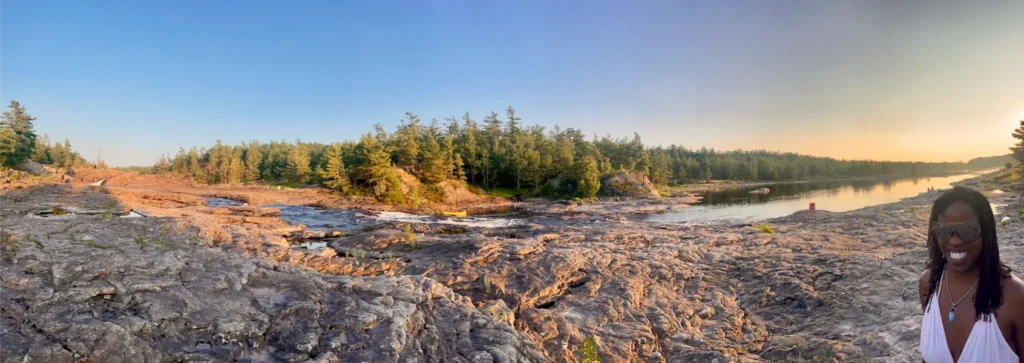 Panorama of daybreak over river with woman at right
