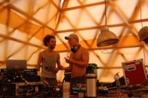 Two DJs inside a yellow structure