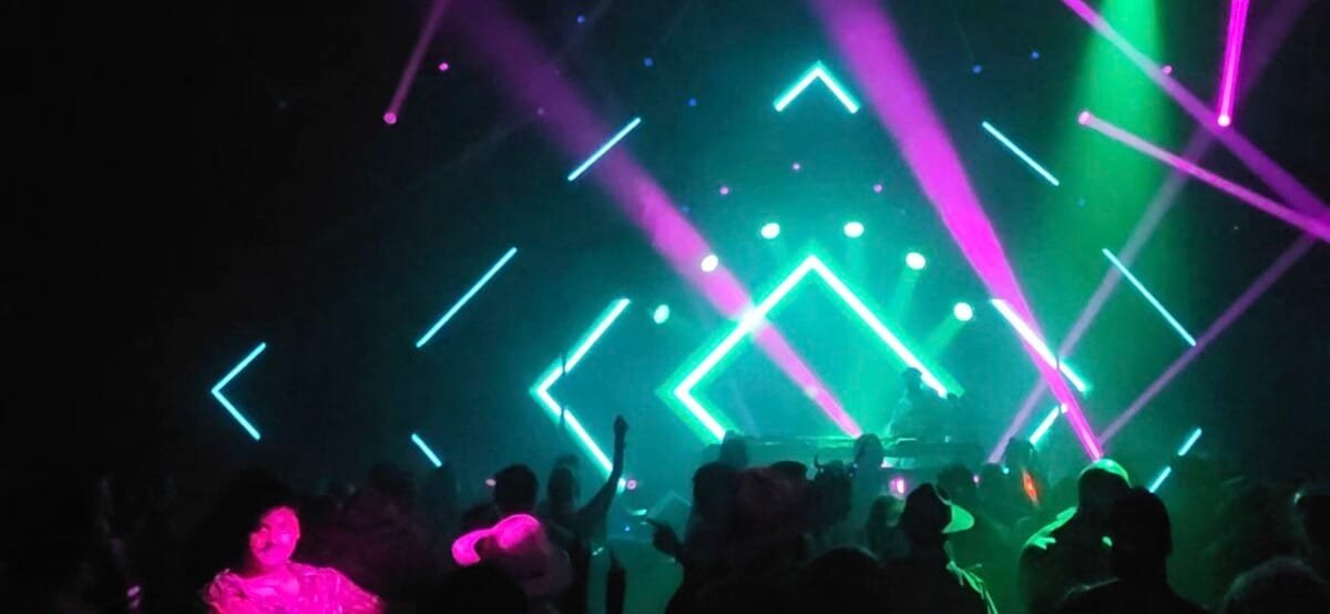Lasers in a large venue with diamond shaped neon colours emitted from LCDs