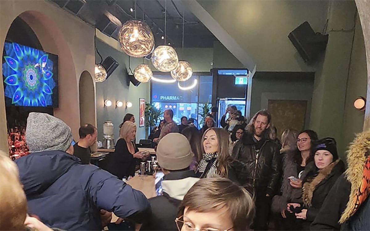 A crowded bar with light balls and curved arches