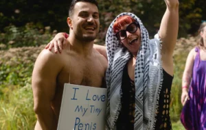 Naked man's chest with a sign "I love my tiny penis" and a woman with head scarf