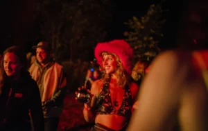 A smiling woman with a pink furry hat and bikini top