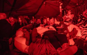 A plounge with four friends surrounded by others