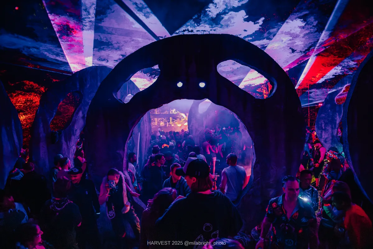 A giant sculpture with a circle and eyes open showing a dancing crowd beyond