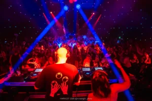 DJs from behind with crowd beyond