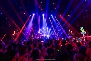 Crowded dance floor lit with red strobe lights