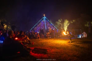 Fire spinner and crowd outside pyramid structure