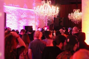 A crowded red lit room of dancers