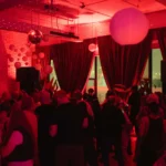 Red lit room with dancing crowd