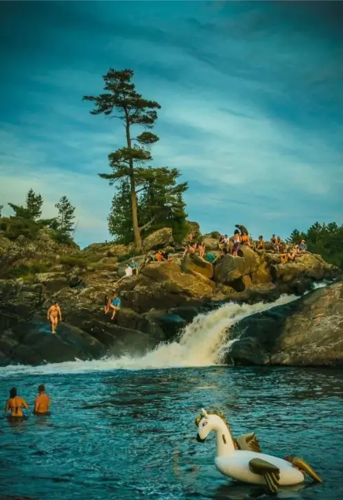 The waterfall at Boreal Canoe Trip with people sitting above