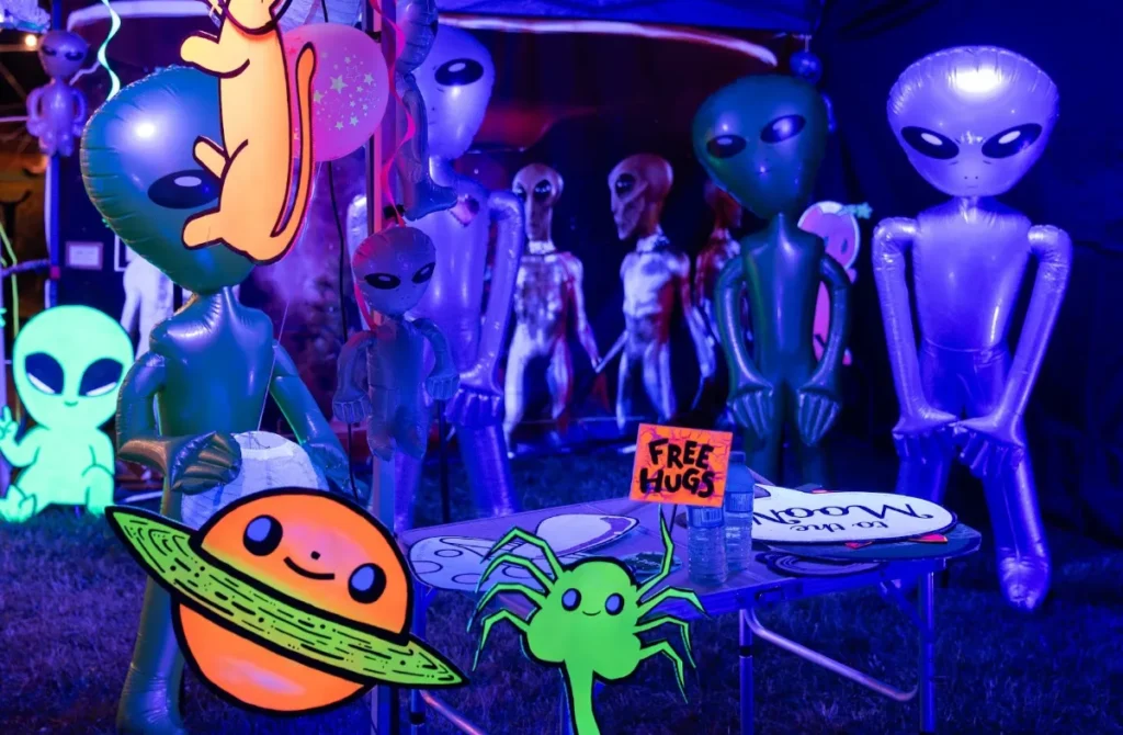 An installation of blow up aliens in purple light