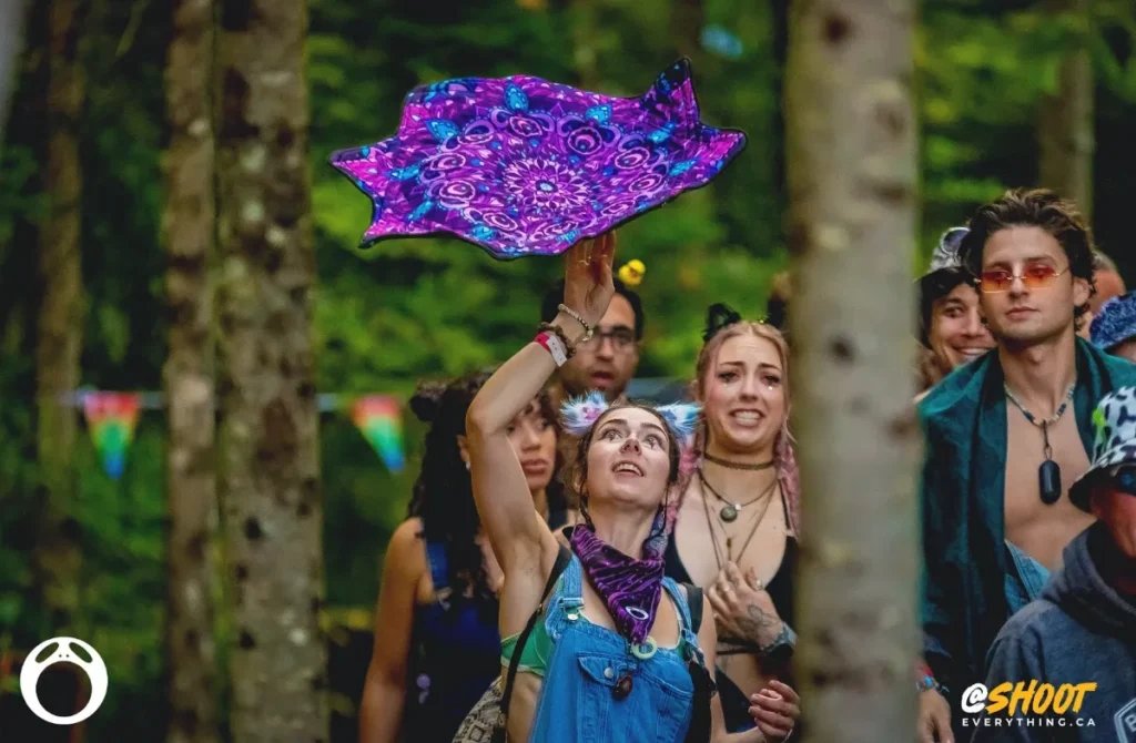 Woman with clown makeup under eyes twirling a purple cloth