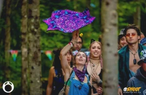 Woman with clown makeup under eyes twirling a purple cloth
