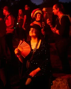Woman with fan by fire