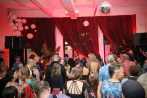 Large room with dancers and red curtains
