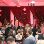 Large room with dancers and red curtains