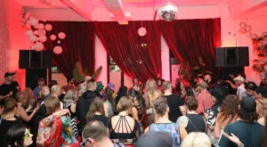 Large room with dancers and red curtains