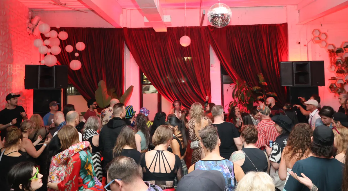 Large room with dancers and red curtains