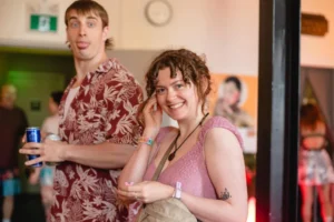 Man with mullet and woman with curly hair at a party