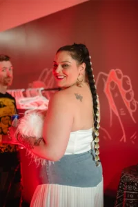 Woman with braided hair and striking jewelry smiles at the camera