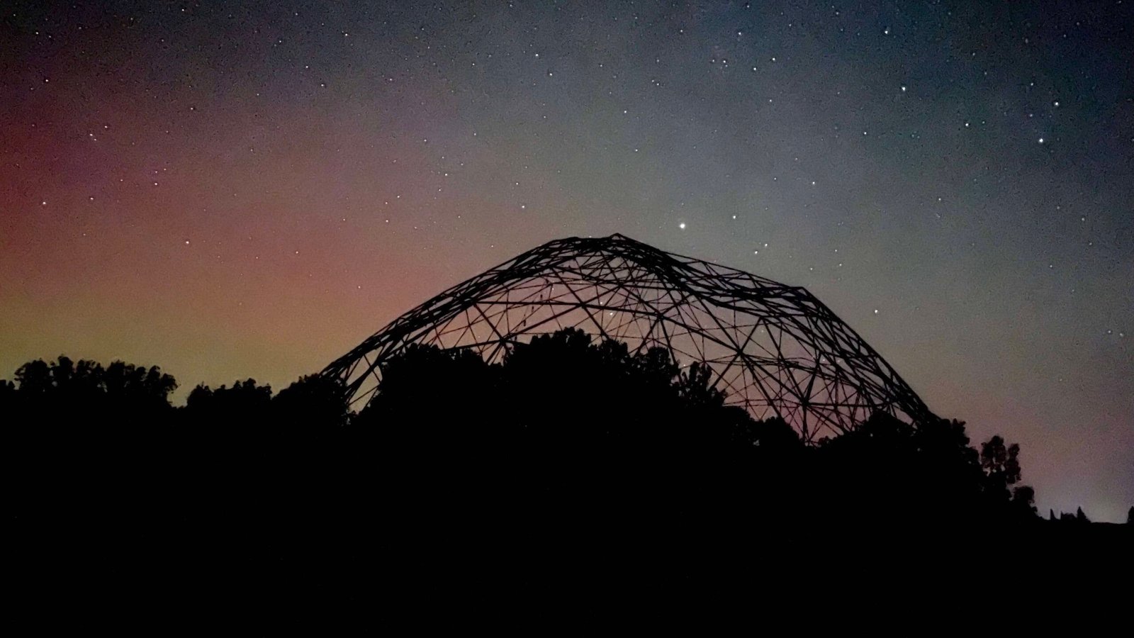 Silhouette of a geodesic dome against the Perseid meteor shower sky