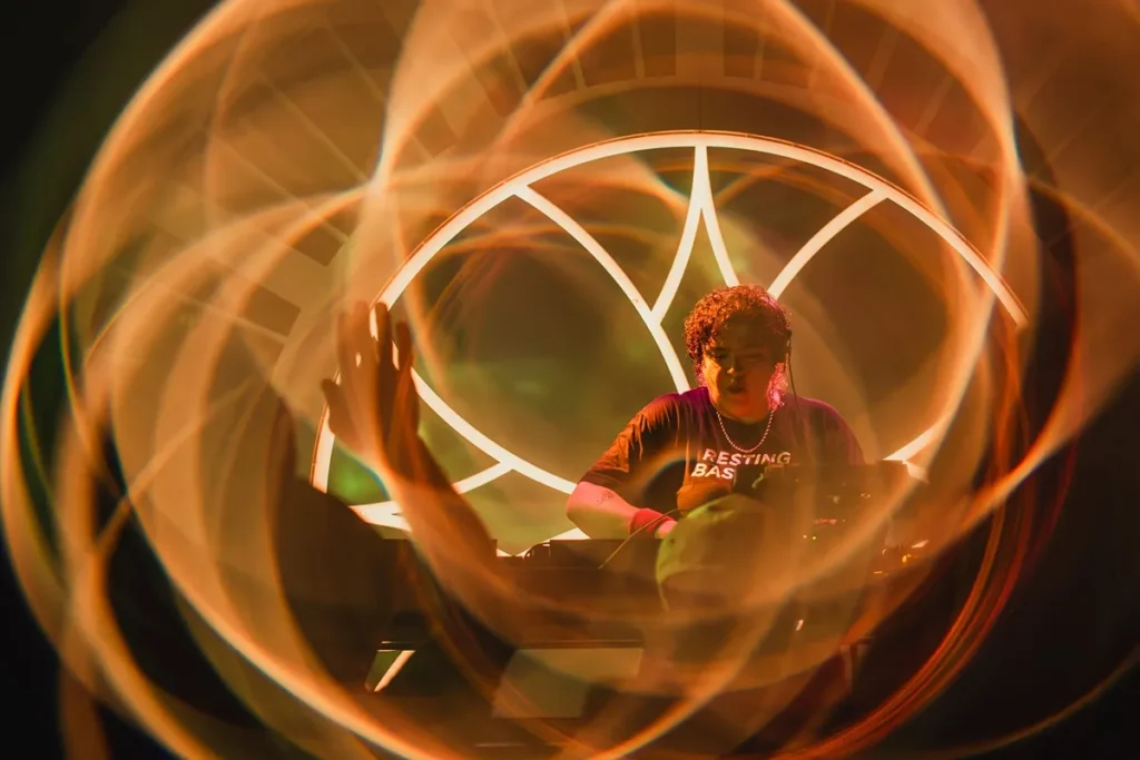 DJ performing at Harvest Festival 2026 with swirling lights